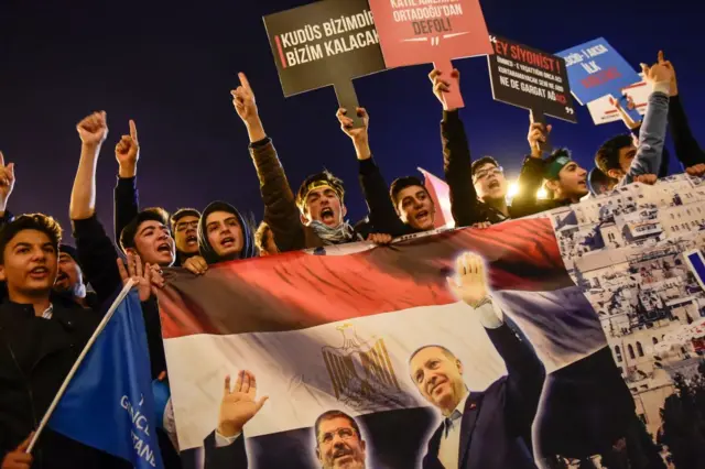 2﻿017'de İstanbul'da İsrail'i protesto için düzenlenen bir eylemde göstericiler, eski Mısır Cumhurbaşkanı Muhammed Mursi ve Türk Cumhurbaşkanı Recep Tayyip Erdoğan'ın fotoğrafları ve Mısır bayrağından oluşturdukları pankartı taşıyor. 
