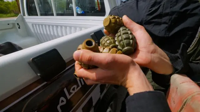 Bir avuç bomba görünüyor arka planda Arapça bir yazı.