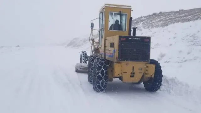 زمین پوشیده از برف که یک موتر مخصوص در حال برف پاکی است.