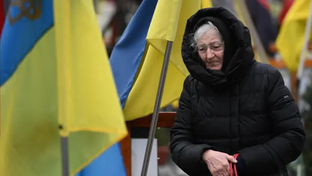 Bir kadın, Lychakiv mezarlığında Ukrayna askerlerinin mezarları arasında yas tutuyor.