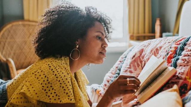 Mulher lendo livro na cama