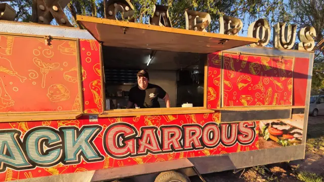 Mulher dentro de um trailer de comida