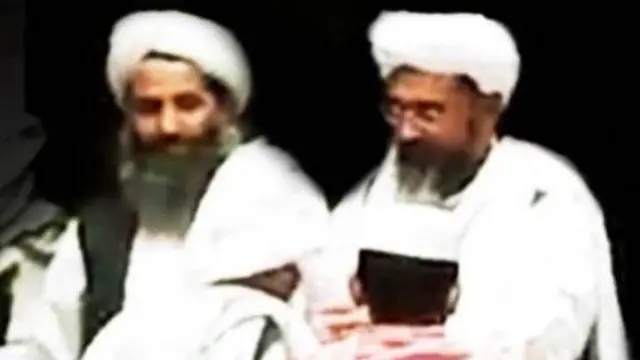 د طالبانو مشر مولوي هبت‌الله اخوندازه او د طالبانو حکومت قاضي القضات عبدالحکیم حقاني ظاهرآ یوه مدرسه کې څنګ په څنګ ناست دي خو عکس له لېرې اخیستل شوی او څېرې یې ډېرې واضح نه ښکاري. دوه کوچني ماشومان هم چې یوه یې لونګی تړلې او د بل سپينه خولۍ په سر ده او د کمرې خوا یې شا ده، عکس کې ښکاري