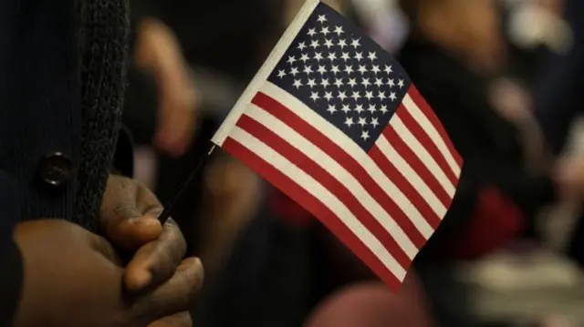 АҚШ давлат байроғини қўлида кўтариб турган одам