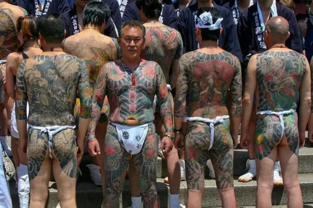 Men wey dey wia pant wit plenti tattoos for bodi