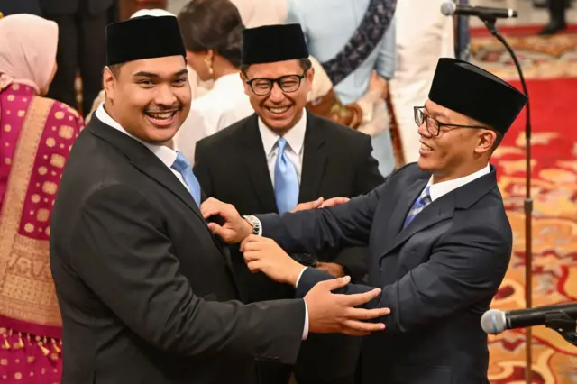 Menteri Luar Negeri Sugiyono (kanan) merapikan dasi Menteri Pemuda dan Olahraga Nandito Ariotedjo (kiri) disaksikan Menteri Kesehatan Budi Gunadi Sadikin (tengah) sebelum upacara pelantikan di Istana Negara, Jakarta, Senin (21/10).