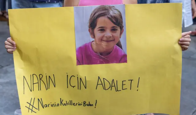 Narin için adalet pankartı taşıyan küçük eller, pankart sarı