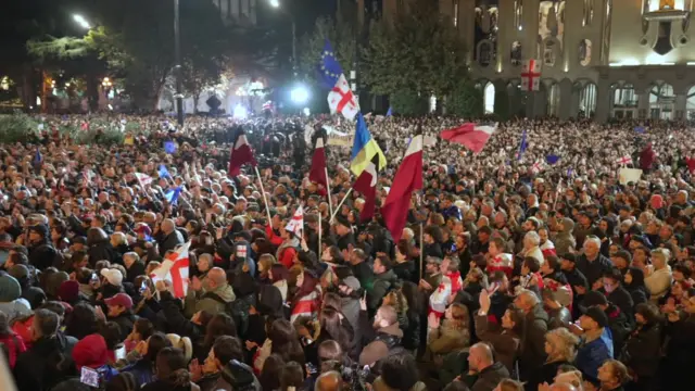 Тбилиси шаҳридаги парламент биноси олдида тўпланган норози намойишчилар