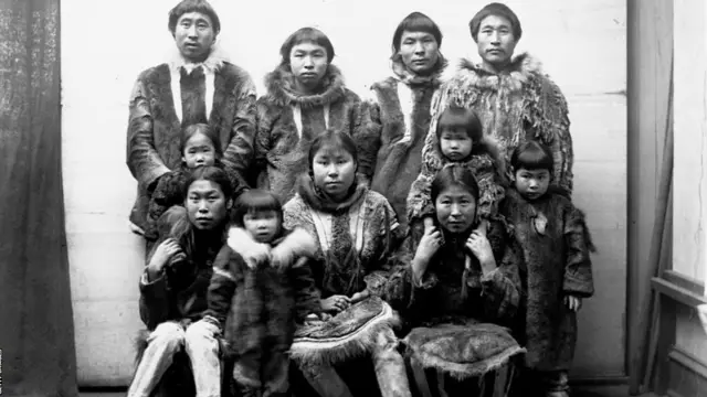 گروهی از مردان، زنان و کودکان اسکیمو با کت‌های خز در سال ۱۸۹۴ در پورت کلارنس، آلاسکا. بومیان آمریکا و آلاسکا تا سال ۲۰۱۸، ۱۶ درصد از جمعیت این ایالت را تشکیل می‌دادند