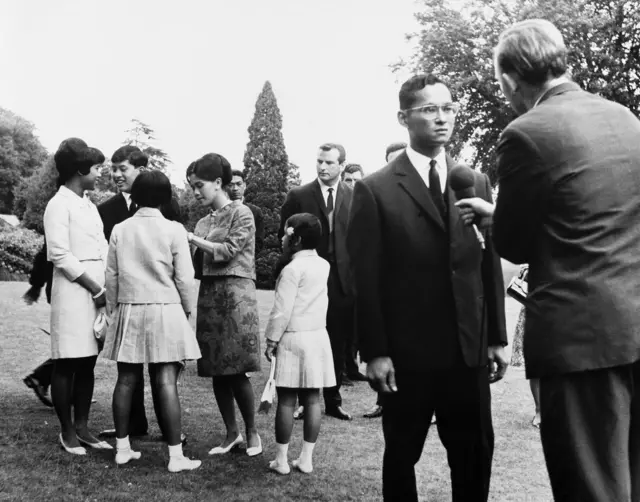 พระบาทสมเด็จพระบรมชนกาธิเบศร มหาภูมิพลอดุลยเดชมหาราชฯ ทรงมีพระราชดำรัสกับสื่อมวลชนอังกฤษที่ทรงเชิญ ณ คฤหาสน์คิงส์บิเชส ที่ประทับส่วนพระองค์ในเมืองซันนิงฮิลล์ มณฑลเบิร์กเชียร์ของอังกฤษ เมื่อ 27 กรกฎาคม 2509 ด้านหลังคือสมเด็จพระนางเจ้าสิริกิติ์ พระบรมราชชนนีพันปีหลวง พระราชโอรส และพระราชธิดา