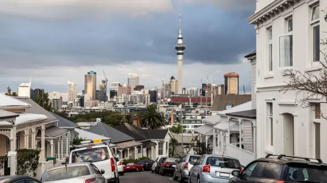Rua de Auckland com nuvens de tempestade ao fundo