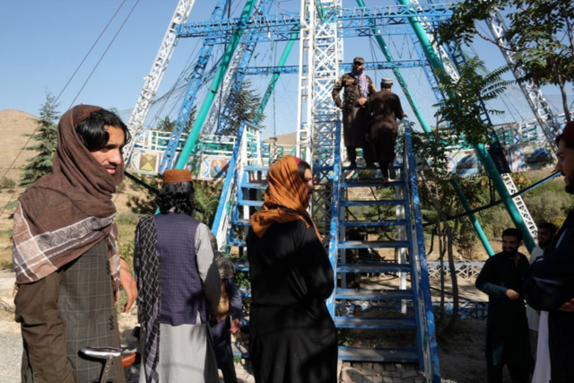 جنگجویان مسلح طالبان در ۱۷ سپتامبر در کابل، منتظر تاب خوردن در پارک تفریحی قرغه در حومه غربی شهر کابل هستند.