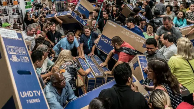 People rush to get discounted TVs in a shop in São Paulo, Brazil, in November 2018.