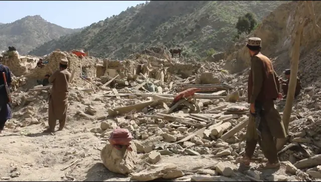 خوست کې ویجاړ شوي کور ته خلک ولاړ دي.