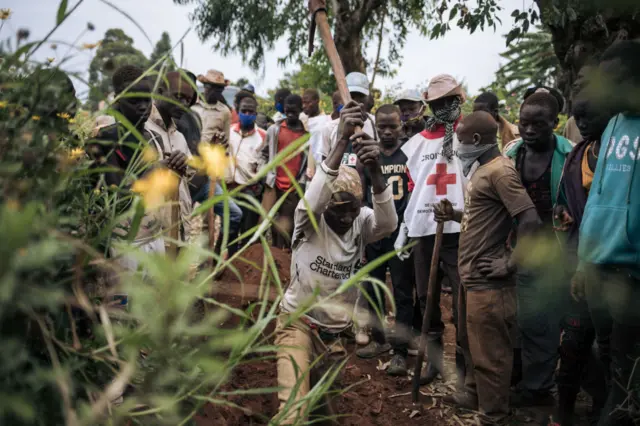 Des volontaires de la Croix-rouge enterrent des morts 