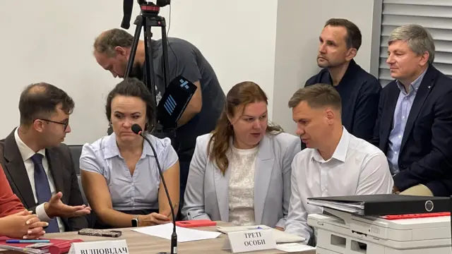 Представники відповідача і третьої сторони (попереду за столом), депутати "ЄС" Володимир В'ятрович та Артур Герасимов (позаду на підвіконні)