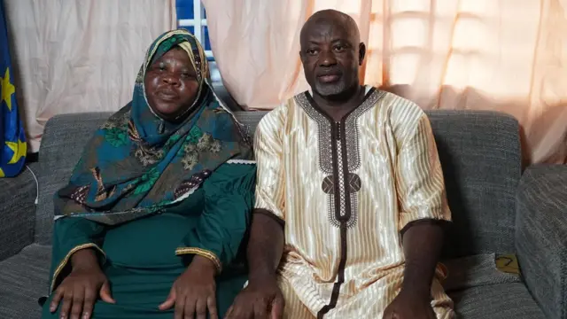Parents sit in their home on a sofa after uniting their family and encouraging them to push to attain their dreams without fear of stigma