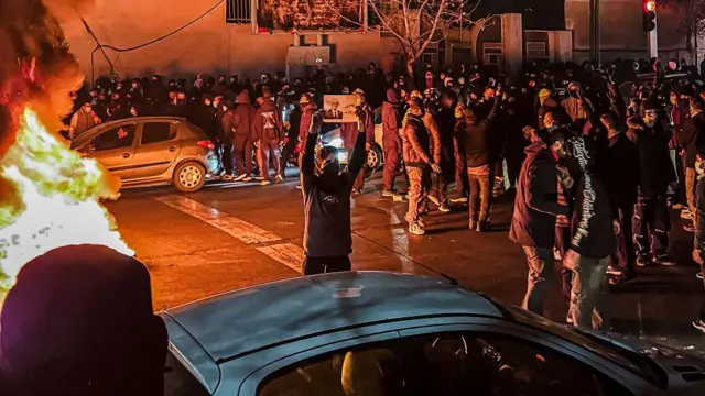 Um grupo de iranianos bloqueia uma rua durante protesto em Teerã