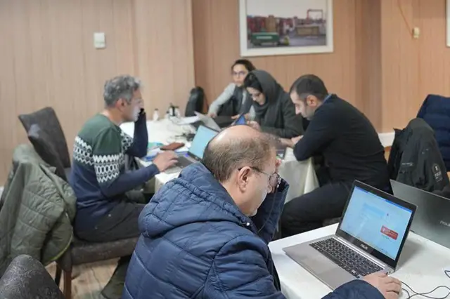 بازرگانان ایرانی پشت میز در اتاق بازرگانی تهران مشغول کار با نیم ساعت دسترسی به اینترنت