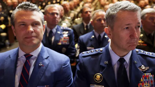 Pete Hegseth (ibumoso) hamwe n'umukuru w'abagaba b'ingabo, Jenerali Dan Caine wo mu ngabo zirwanira mu kirere, bateze amatwi ijambo rya Perezida w'Amerika Donald Trump, ku itariki ya 30 Nzeri (9) mu mwaka wa 2025. 