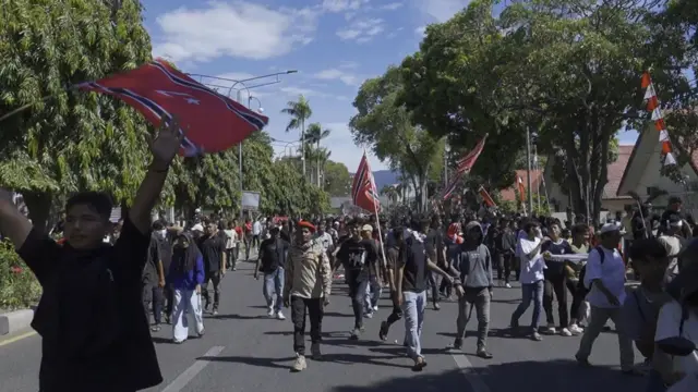 Sejumlah orang membentangkan bendera bulan bintang dalam Peringatan 21 tahun Hari Damai Aceh, pada Sabtu (15/08).