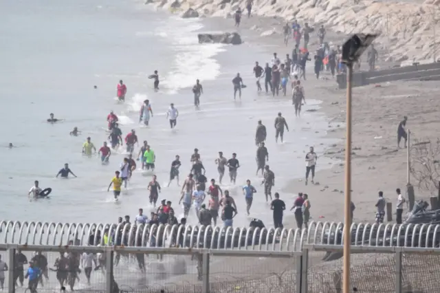 Varios migrantes intentan cruzar la frontera a nado el 30 de julio de 2026 en Ceuta.