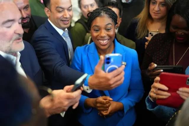 Muhafazakar Parti lideri Badenoch bir cep telefonuna bakarken gülümsüyor