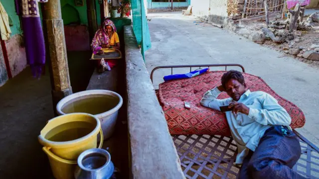 Containers of water drawn from a partially dried up well sit in a house on May 26, 2023 in Khokher Viheer village, Peth Taluka, Nashik, Maharashtra.