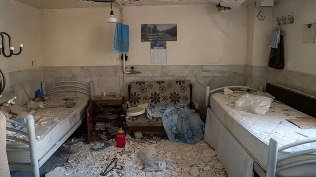 কারাগারের একটি হাসপাতালের দুটি বিছানা ও একটি সোফার ওপর দেয়ালের অসংখ্য ভাঙা টুকরো পড়ে আছে