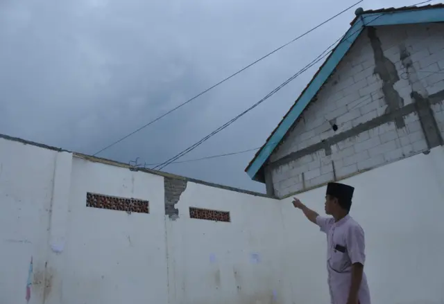 Seorang warga menunjukkan atap kamar yang telah ambruk di Pondok Pesantren Salafiyah Syafi'iyah Syekh Abdul Qodir Jaelani, Desa Belimbing, Besuki, Situbondo, Jawa Timur, Rabu (29/10/2025).
