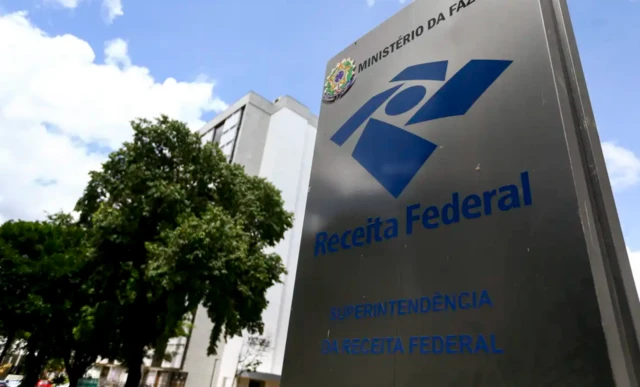 Totem com logotipo da Receita Federal ao lado de uma árvore