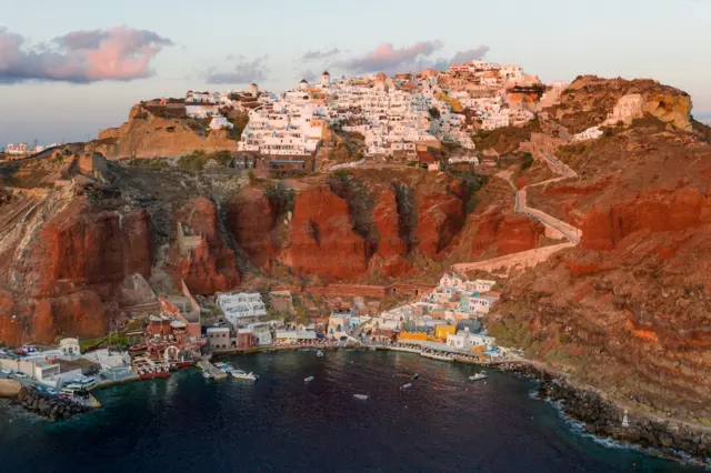 Santorini'deki yerleşimlerin ve bir limanın fotoğrafı.