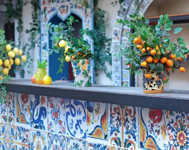 Decoración con baldosas, y floreros repletos de limones y naranjas sicilianas