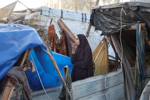 فتاة تنظر امامها وسط الخيام في منطقة دير البلح 