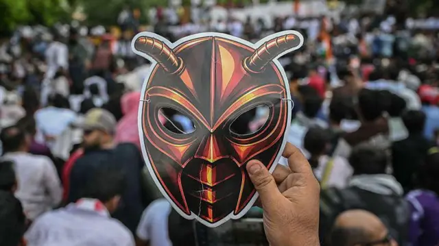 Un simpatizante del Partido Popular Cucaracha (Cockroach Janta Party, CJP) sostiene en alto una máscara de cucaracha en una protesta por supuestas irregularidades en los principales exámenes públicos en Delhi