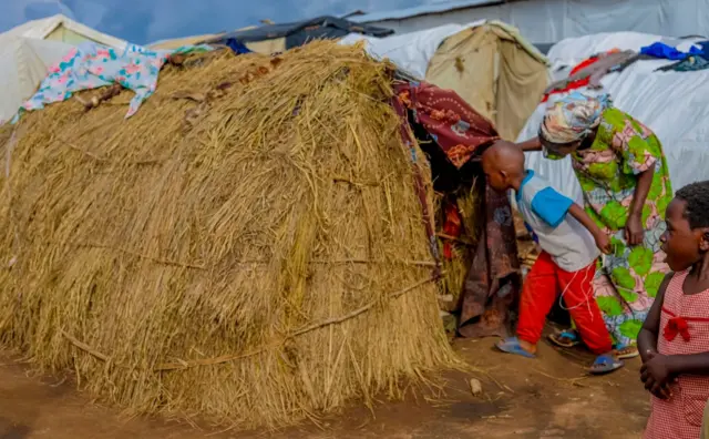 Umwana w'umunecongo afatiwe igitenge gikora nk'umuryango ngo yinjire mu karuri abamwo mw'ikambi ya Busuma mu buseruko bw'Uburundi