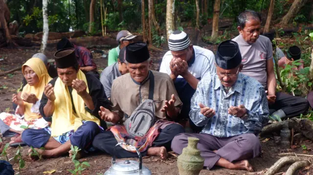 Muhammad Sani (berbaju biru) memimpin doa bersama warga yang turut berziarah di makam tua Lubuk Lanjut, Kampung Pasir Panjang, Rempang, Jumat, 6 September 2024. 