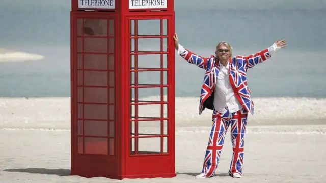 Sir Richard Branson on one of The World Dubai islands with a red telephone box