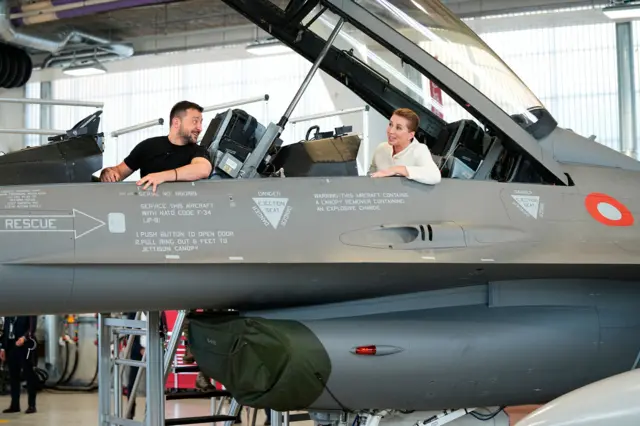 Ukrainian President Volodymyr Zelensky and Danish Prime Minister Mette Frederiksen sit inside F-16 fighter jet