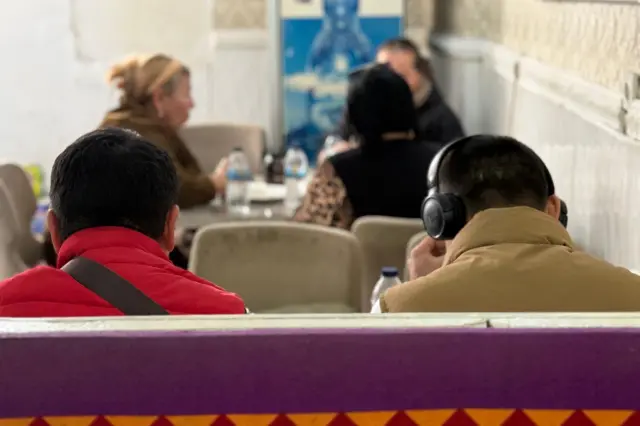 Ankara'daki bir kırgız restoranında yemek yiyerek kadın erkek sohbet eden bir grup Kırgız göçmen.