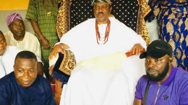 Sunday Igboho wọ aṣọ olómi búlúù, ó loso ni ọwọ àlàáfíà, nígbà tí Ọba tó joko lórí ìtẹ́, tó wọ aṣọ funfun àti ìlẹ̀kẹ̀ lọrun wa pẹlu rẹ, ti ẹlòmíràn tó wọ aṣọ aláwọ̀ elese àlùkò naa si loso lọwọ ọtun Kabiyesi náà.