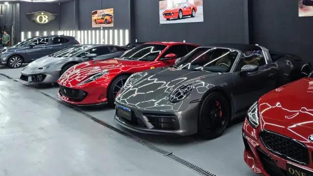 Carros de luxo lado a lado dentro de concessionária