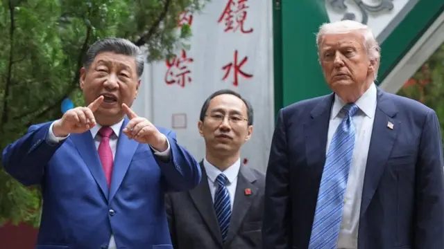 ダークスーツ姿の両首脳が横並びに立っている。習氏は両手を前に突き出し、両手の人差し指を立てて近づけながら、口を開いている