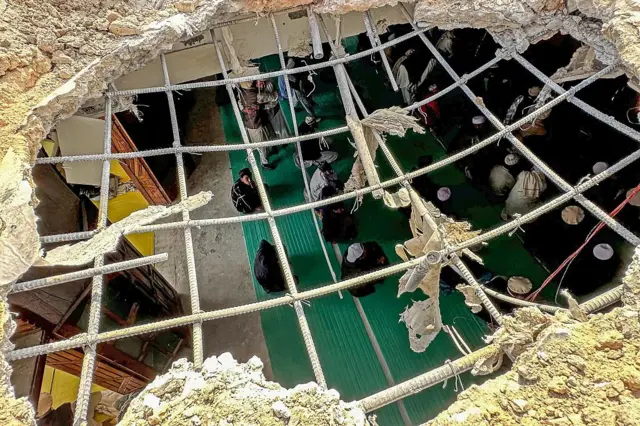 ख़ैबर पख़्तूनख्वा में एक हमले से प्रभावित मस्जिद में नमाज़ पढ़ते लोग