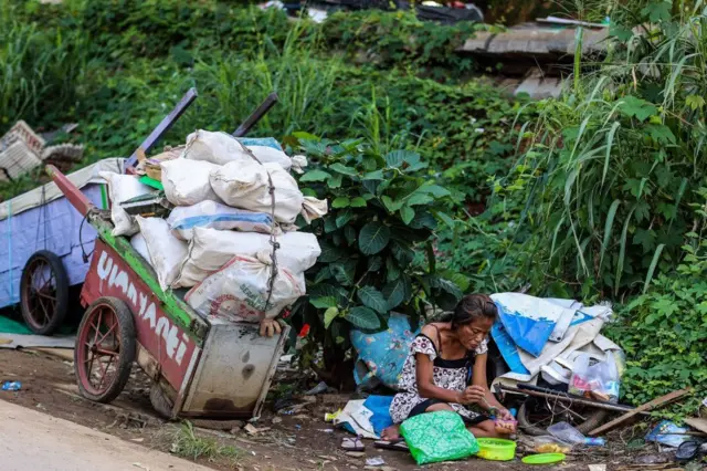 Seorang perempuan tunawisma terlihat menikmati makanannya di Jakarta.