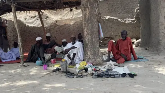 Wasu mutane zaune a ƙarƙashin wata bishiya