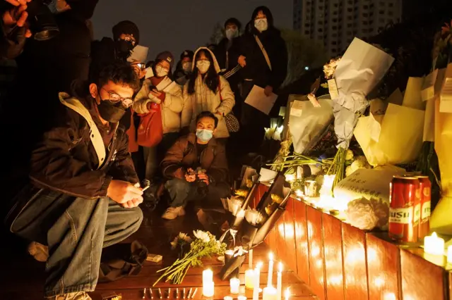 People gather for a vigil during a commemoration of the victims of a fire in Urumqi, as outbreaks of the coronavirus disease (COVID-19) continue, in Beijing,