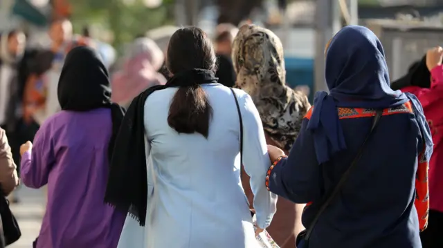 زنان ایرانی برخی بدون حجاب در خیابانی در تهران، ایران، ۶ اکتبر ۲۰۲۳ قدم می زنند.