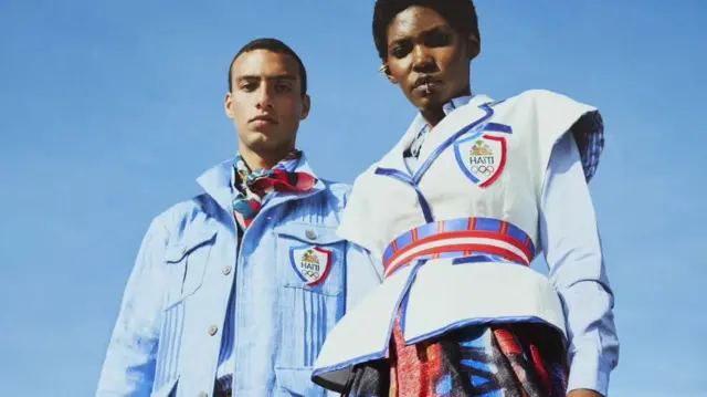 Um homem e uma mulher usando o uniforme olímpico do Haiti