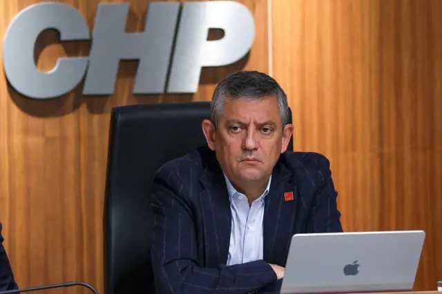 Cumhuriyet Halk Partisi Genel Başkanı Özgür Özel bir toplantıda masada oturuyor. Önünde bir bilgisayar var